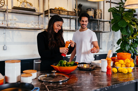 Young woman and man preparing food in the kitchen preventing food waste.