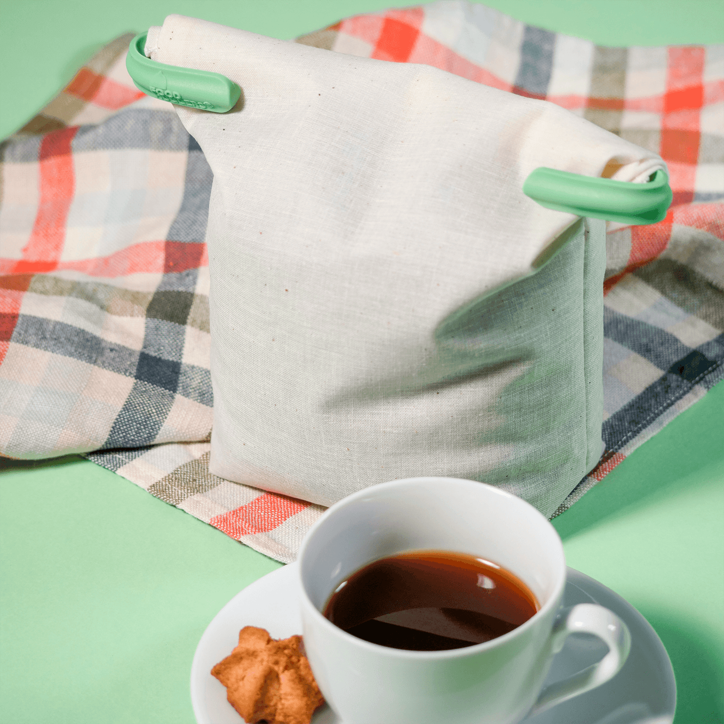 A Reusable alternative to plastic bags Food Huggers Fabric Coffee Bag on a plaid blanket next to a cup of coffee