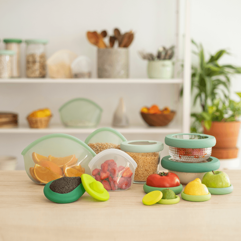 Set of thirteen sustainable and eco-friendly food exchanges that keep food fresh, snacks and leftovers on a wooden table.