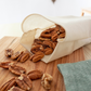 Fabric Bulk Bag reusable and dishwasher safe, containing almonds on a wooden table