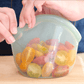 "Person closing a silicone bag that preserves tomatoes to have zero waste for a sustainable kitchen"