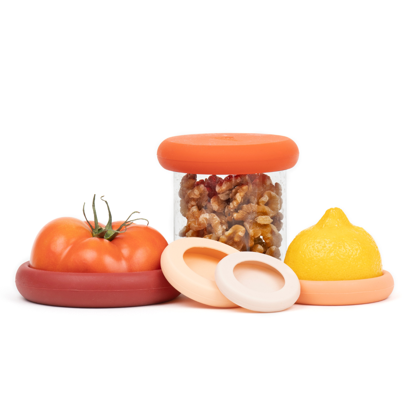 Set of five orange sustainable Food Huggers that seal and preserve a tomato, and also a replacement lid for jars