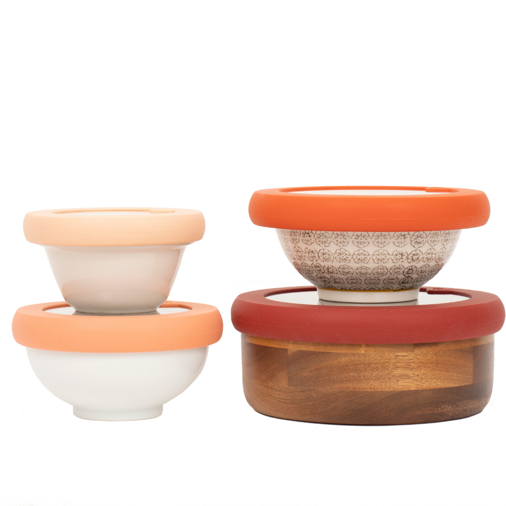 Two white bowls one on top of the other next to two bowls one on top of the other all with sustainable, adjustable silicone lids to preserve food