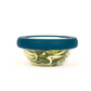 Glass bowl filled with vegetables with sustainable blue hugger lids for preserving food