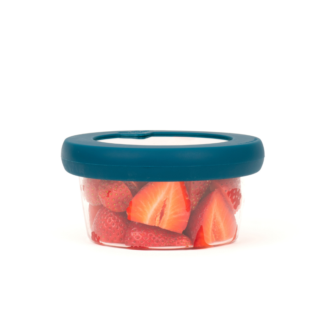 Glass bowl with pieces strawberries with a sustainable blue hugger lids to preserve food